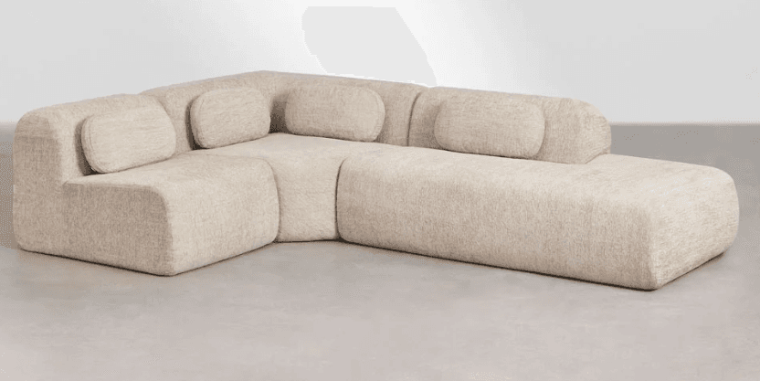 An L-shaped modular sectional sofa in a light beige, textured fabric, featuring soft, rounded edges and separate, integrated back cushions. The design is low-profile and contemporary, emphasizing comfort and an organic aesthetic. — 3D model