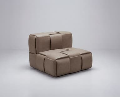 A modular armchair with a low profile and cushioned seating. The piece is characterized by its woven or quilted exterior, creating a series of padded segments. It appears to be upholstered in a soft material, possibly leather or a high-quality faux leather. The design is contemporary and minimalist, with clean lines and a focus on comfort and texture. — 3D model