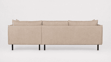 A contemporary sectional sofa, seen from the rear and side, upholstered in light beige/greige fabric with black metal legs. It features multiple loose back cushions and a low-profile design. — 3D model