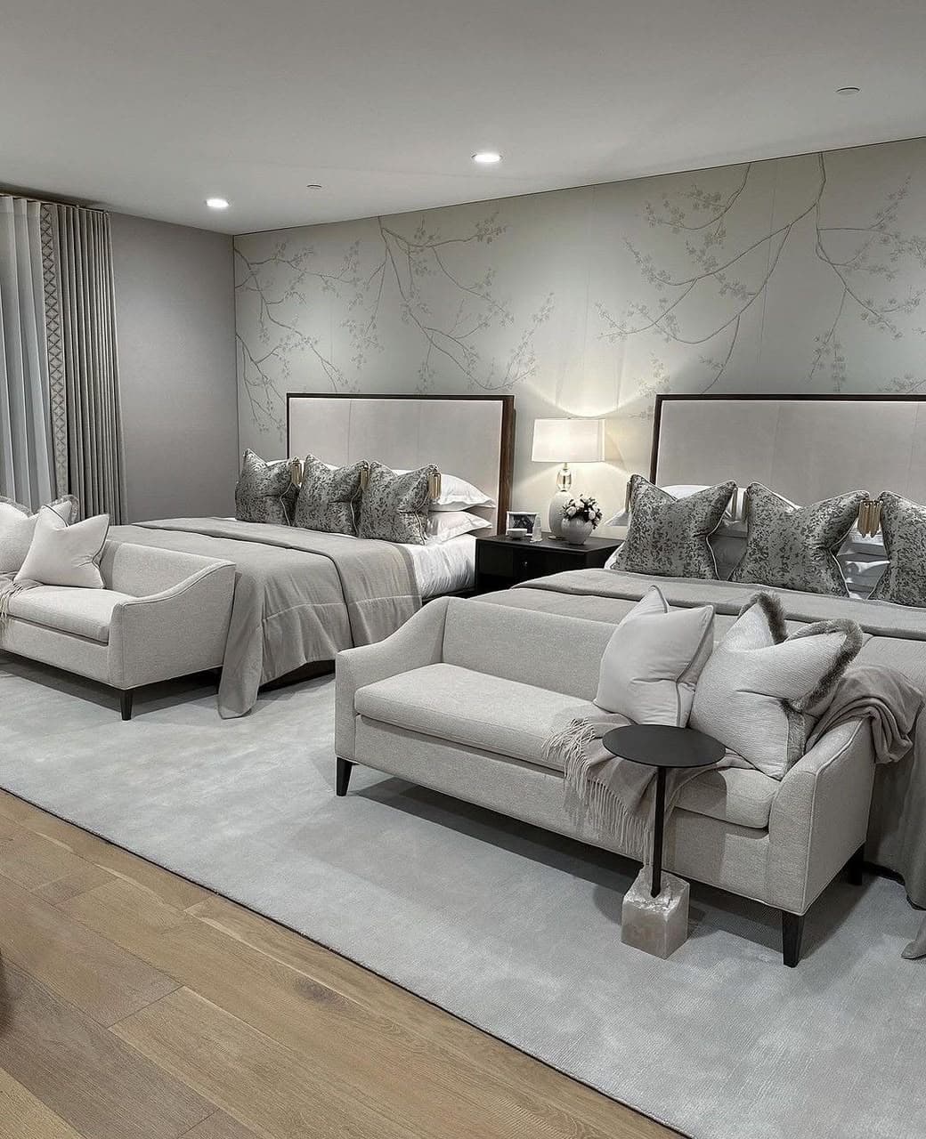 A contemporary king-size bed featuring a dark wood frame and a tall, rectangular upholstered headboard in a light neutral fabric. The bed is dressed with white and grey bedding, including multiple decorative pillows, and is positioned within a bedroom setting with matching elements. — 3D model
