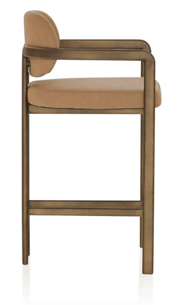 A contemporary bar stool featuring a sturdy metal frame with a bronzed finish, complemented by a padded seat and a gently curved backrest, both upholstered in a light brown fabric. The design includes integrated armrests and a footrest bar for comfort. — 3D model