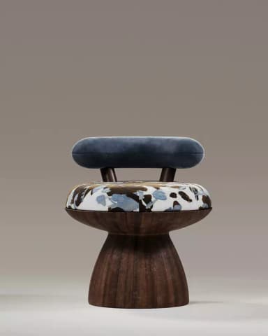An accent chair with a distinctive, sculpted design. The seat is round and upholstered with a fabric featuring a floral or abstract pattern in shades of blue, brown, and white. The base of the chair is a solid, pedestal-like structure with a dark wood grain finish. A curved, cushioned backrest in a light grey, textured fabric extends upwards from the back of the seat, supported by dark brown cylindrical posts. — 3D model