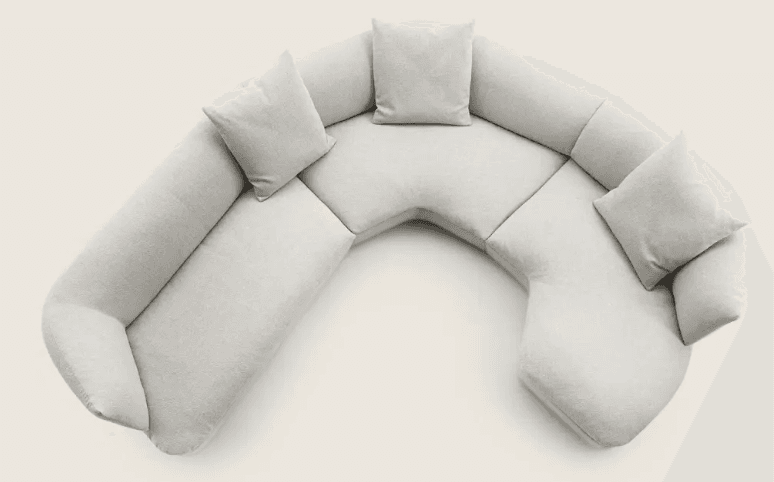 A sectional sofa with a curved, semi-circular configuration. It features multiple seating sections and includes four throw pillows. The overall design is modern and minimalist, with soft, rounded edges and a plush upholstery. — 3D model