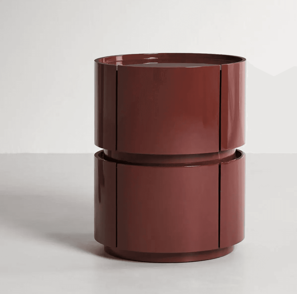 A dark red, high-gloss lacquered cylindrical table composed of two stacked tiers. Each tier features segmented panels that suggest internal rotating storage compartments. The table has a flat top surface and a clean, modern aesthetic. — 3D model