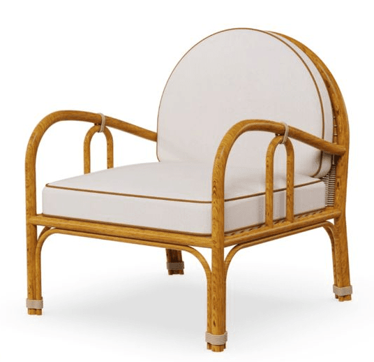 A light brown natural rattan lounge chair with a distinctive rounded backrest and armrests, featuring thick white seat and back cushions with brown piping. The chair has a sturdy, curved rattan frame and decorative rope accents on the leg bases and where the armrests meet the back. — 3D model