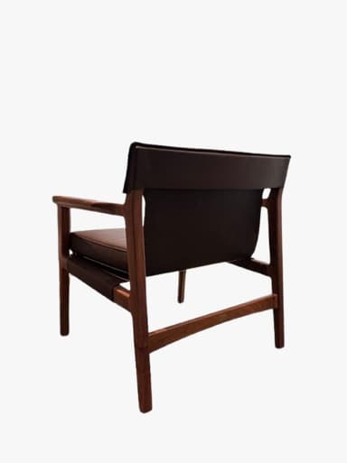A mid-century modern armchair featuring a solid dark wood frame and dark brown leather upholstery. The chair has a minimalist design with straight lines, exposed wooden armrests, and subtly tapered legs. It includes separate seat and back cushions for comfort. — 3D model