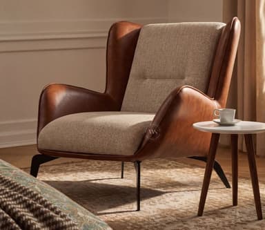 A modern lounge chair featuring a distinctive two-tone upholstery design. The outer shell and armrests are covered in smooth brown leather, while the inner seat, backrest, and side panels are upholstered in a textured light beige fabric. The chair has a comfortable, slightly reclined back with a single button tuft on the lower back. It stands on slender, splayed dark metal legs. — 3D model