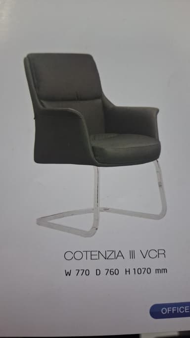 A dark gray upholstered armchair with a polished chrome cantilever base, featuring a contemporary design with integrated armrests and a padded seat and back. — 3D model