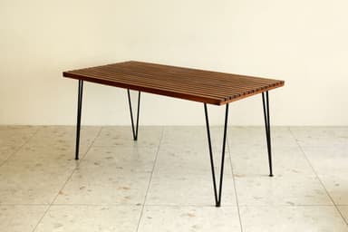 A rectangular coffee table featuring a top constructed from uniformly spaced wooden slats, supported by four slender black metal hairpin legs. — 3D model