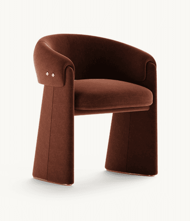 A contemporary armchair featuring a sculptural, curved silhouette upholstered in rich reddish-brown velvet. It has wide, solid, U-shaped legs and brass stud detailing on the back. — 3D model