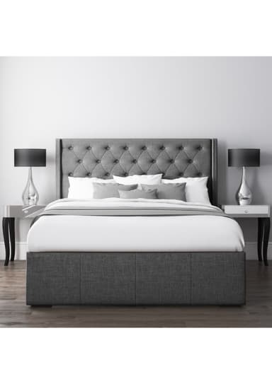 A contemporary grey fabric upholstered bed featuring a deeply tufted, winged headboard with decorative nailhead trim, and a platform base that appears to incorporate storage. — 3D model