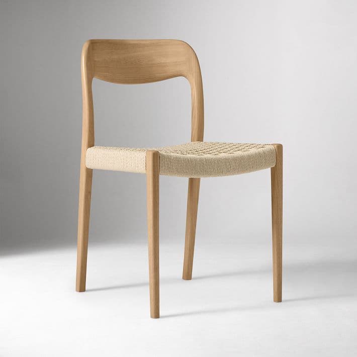 A light wood chair featuring a curved backrest and a woven seat. The chair stands on four straight, slightly tapered wooden legs, showcasing a minimalist design. — 3D model
