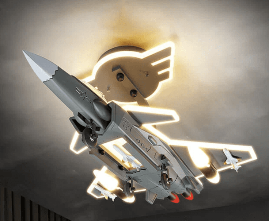 A ceiling-mounted light fixture featuring a detailed model of a fighter jet, surrounded by illuminated contours that suggest a flight path or abstract wings. The primary color of the jet is grey, with white and red accents. The light emitted is a warm white. — 3D model
