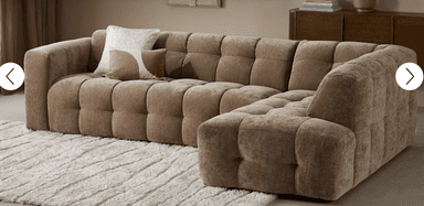 An L-shaped modular sectional sofa featuring extensive deep button tufting across all surfaces, including the low-profile arms and backrest. It is upholstered in a textured taupe fabric, presenting a modern, blocky silhouette. — 3D model