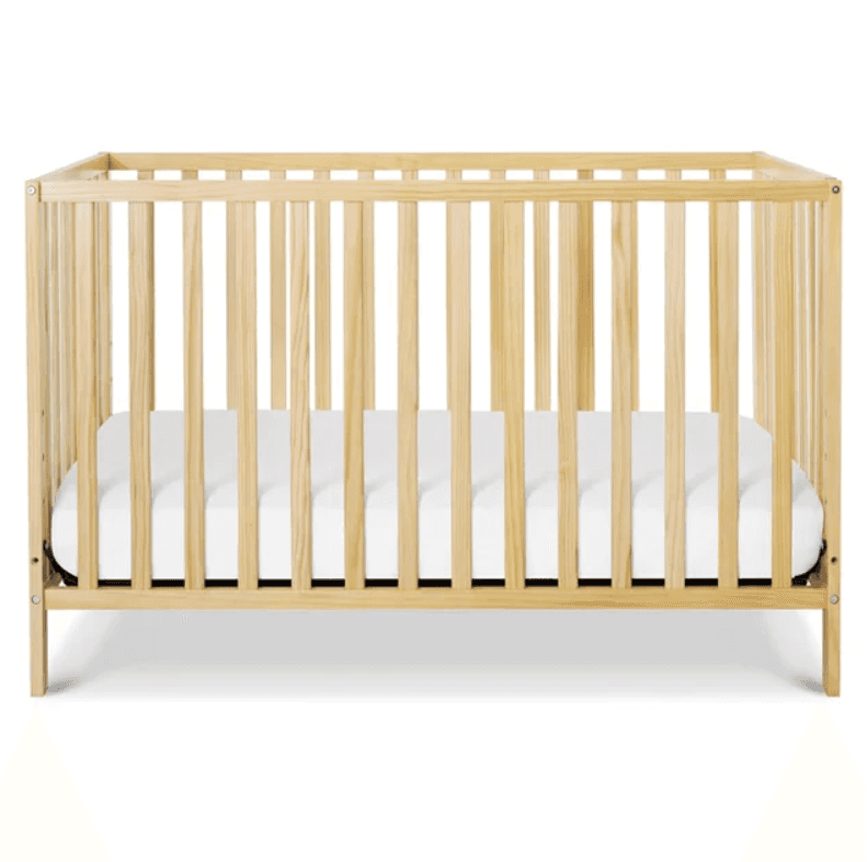 A light natural wood baby crib with vertical slatted sides and a white mattress inside, presented on a white background. — 3D model