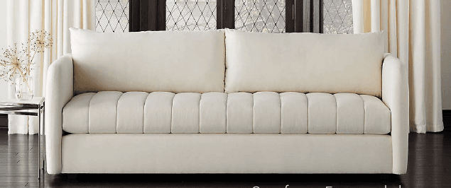 A modern three-seater sofa upholstered in a light-colored fabric. It features clean lines, wide track arms, and vertically channel-tufted seat cushions with two loose back cushions. — 3D model