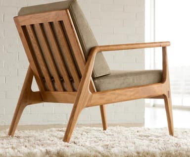 A two-view technical drawing of a modern lounge chair, featuring a sturdy wooden frame, padded seat and back cushions, and integrated armrests. The diagram includes precise dimensions for height, width, and depth. — 3D model