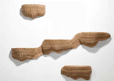 A trio of wall-mounted woven wicker seats arranged in a staggered, ascending pattern. Each seat is a distinct, curved basket-like form, constructed from natural-colored wicker. The design appears to be avant-garde, with the seats projecting outwards from a white wall. The closest seat on the left is the largest and lowest, with the subsequent seats progressively smaller and higher. — 3D model
