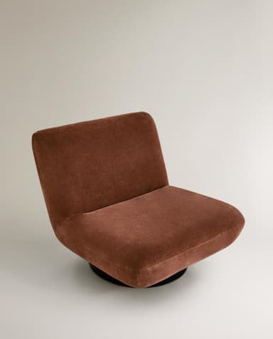 A contemporary armchair with a low profile and plush upholstery. The chair features a rounded silhouette, a supportive backrest, and a deep seat. It is mounted on a circular, black swivel base, allowing for 360-degree rotation. The fabric appears to have a soft, velvety texture. — 3D model