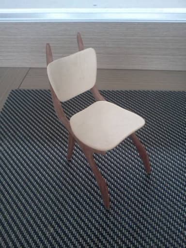 A modern dining chair featuring a gracefully curved bentwood frame in a medium wood tone, complemented by a light-colored, contoured plywood seat and backrest. — 3D model