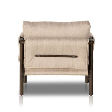 A modern lounge chair featuring an exposed dark-finished metal or wood frame supporting thick, light-beige fabric upholstery in a relaxed, sling-style design. The chair includes a padded backrest and seat cushion, with a horizontal bar detail visible on the rear securing the fabric. — 3D model