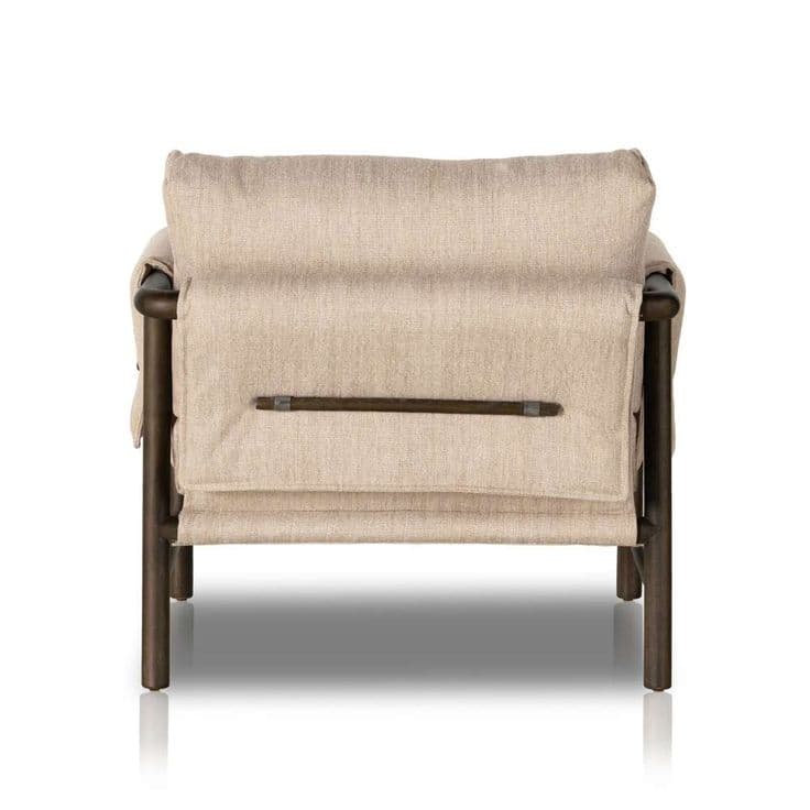 A modern lounge chair featuring an exposed dark-finished metal or wood frame supporting thick, light-beige fabric upholstery in a relaxed, sling-style design. The chair includes a padded backrest and seat cushion, with a horizontal bar detail visible on the rear securing the fabric. — 3D model