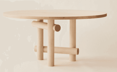 A round dining table with a light wood finish. The table features a flat, circular top and a unique base constructed from cylindrical wooden pieces arranged in an abstract, sculptural manner. The legs are vertical cylinders, connected by horizontal and angled cylindrical supports, creating a visually interesting and modern design. — 3D model