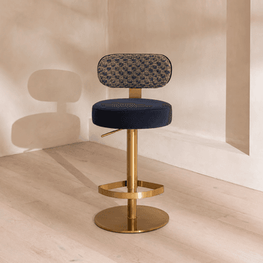 A modern adjustable height bar stool featuring a dark blue velvet upholstered seat and a patterned woven fabric backrest. It is supported by a polished golden metal column, a circular footrest, and a wide circular base. — 3D model