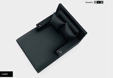A contemporary, sleek black faux leather chaise lounge featuring a low backrest, broad fixed armrests with integrated metal cupholders, and two matching throw pillows. — 3D model