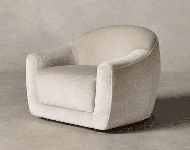 A contemporary club armchair upholstered in a light beige, textured fabric, resembling bouclé. The chair features a distinctive rounded, barrel-like silhouette with a wide, deep seat and integrated, subtly curved armrests that flow seamlessly into the backrest. The entire piece is generously padded, presenting a soft, inviting form. Small, dark wooden feet are visible at the base, slightly lifting the chair off the floor. Its design prioritizes comfort and a modern, organic aesthetic. — 3D model