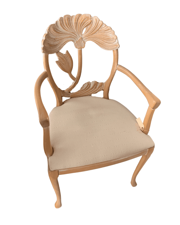 An elegant carved wood armchair featuring an intricately designed backrest with botanical or shell-like motifs, upholstered seat, and curved legs. The frame is light-toned wood, and the upholstery is a neutral beige fabric. — 3D model