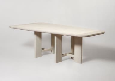 A rectangular dining table crafted from light-colored wood, featuring a slatted top with gently rounded corners. The table is supported by two distinct trestle-style bases, each composed of two vertical elements braced by a horizontal stretcher near the floor. The wood exhibits a bleached or limed finish, emphasizing its grain and contributing to a minimalist aesthetic. — 3D model