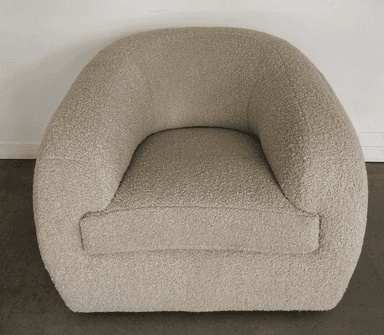 A rounded armchair with a plush, textured upholstery. The armchair features a deep seat and a wraparound backrest that seamlessly integrates into the armrests. The texture appears to be a boucle or similar looped fabric, giving it a soft and inviting appearance. — 3D model