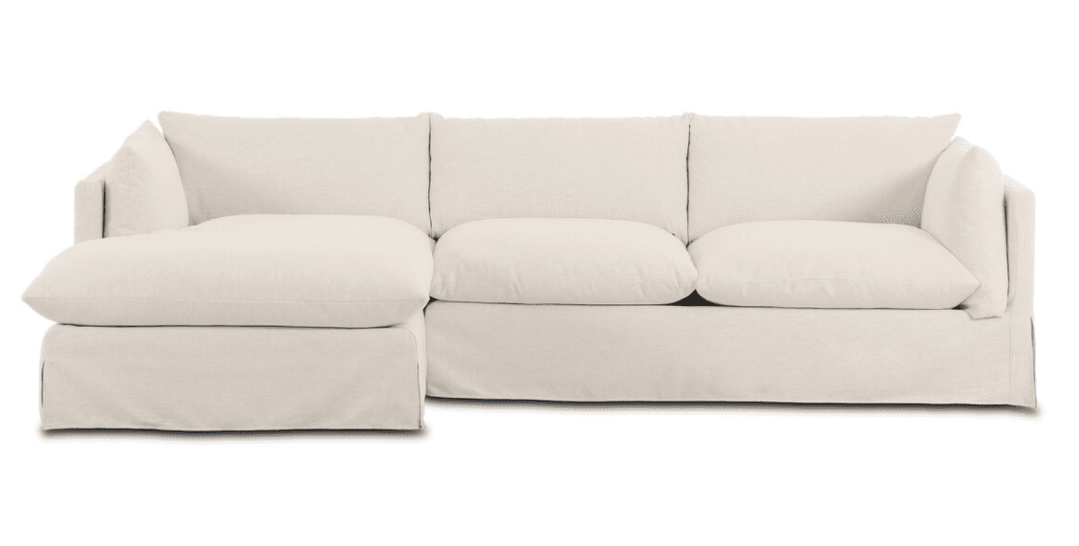 A large, contemporary sectional sofa featuring a left-hand facing chaise lounge, upholstered in a light-colored, slipcovered fabric with plush cushions. — 3D model