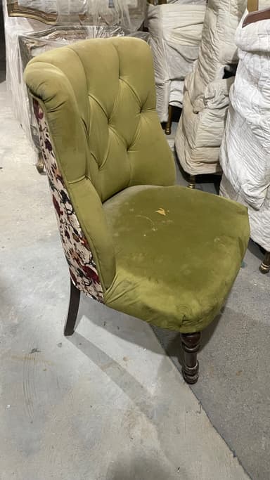 A tufted armchair with a high back and upholstered seat and sides. The main upholstery is a solid olive green velvet, while the back and sides feature a contrasting floral fabric in shades of burgundy, green, and cream. The chair has four turned wooden legs in a dark stain. — 3D model