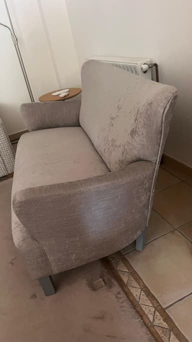 A two-seater sofa with a curved back and armrests. The upholstery appears to be a textured fabric with a subtle distressed pattern. The legs are angular and support the sofa from underneath. — 3D model