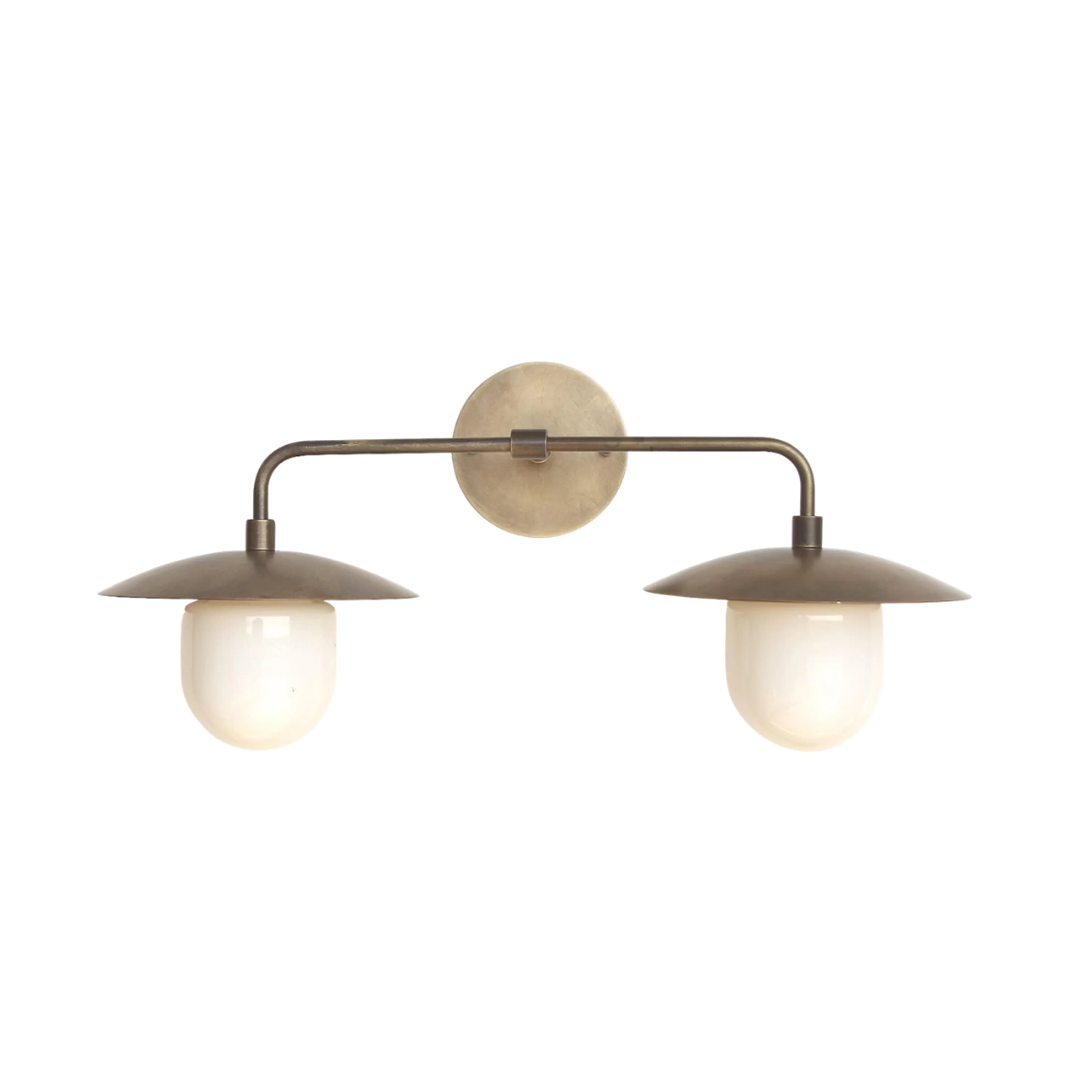 A contemporary double wall sconce featuring an aged brass finish and two opal glass diffusers. It has a circular wall mount from which extends a horizontal arm, supporting two downward-facing lights. Each light has a shallow, dome-shaped metal shade covering a capsule-shaped opal glass diffuser. — 3D model