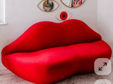 A stylized sofa designed to resemble a pair of human lips. The piece features rounded, voluminous forms characteristic of lips, upholstered in a vibrant red fabric. It appears to be a two-seater or love seat design, with a distinct curve and depth that suggests a comfortable seating experience. The overall form is playful and avant-garde. — 3D model