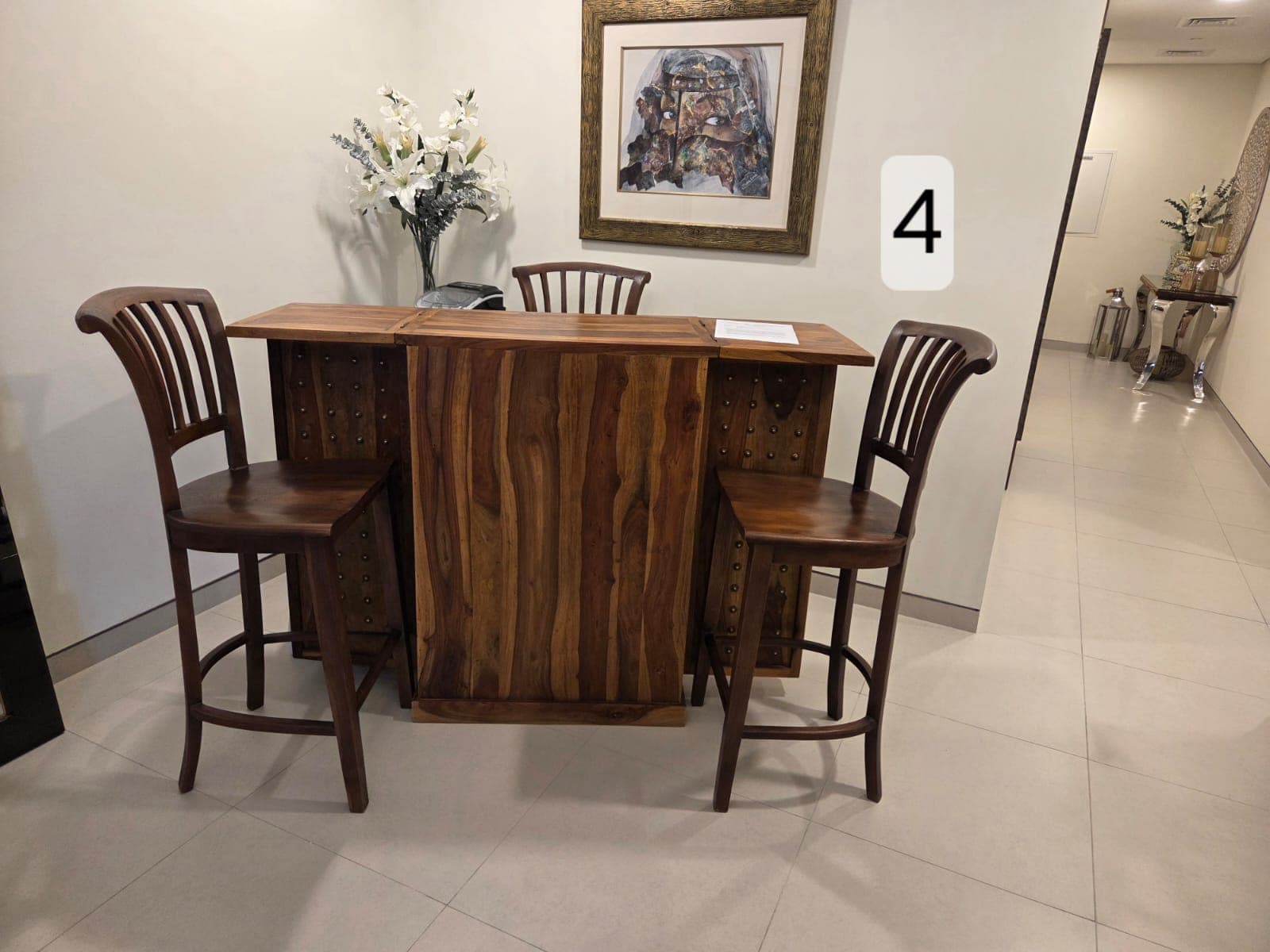 A rustic solid wood home bar set consisting of a rectangular bar counter with an integrated footrest and four matching wooden bar stools with slatted backs and curved seats. The set is made from natural, light-to-medium tone wood. — 3D model