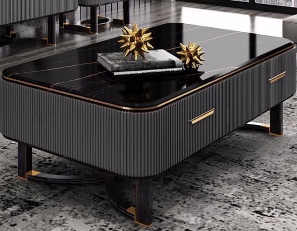 A rectangular coffee table featuring a polished black marble top with delicate gold veining. The body of the table is dark, possibly black wood, with distinct fluted or reeded paneling on the long sides. It incorporates two drawers, indicated by gold-toned bar handles. The table rests on a unique base composed of two dark-toned, possibly wood or metal, curved elements with gold-toned accents, providing a modern and sophisticated aesthetic. — 3D model