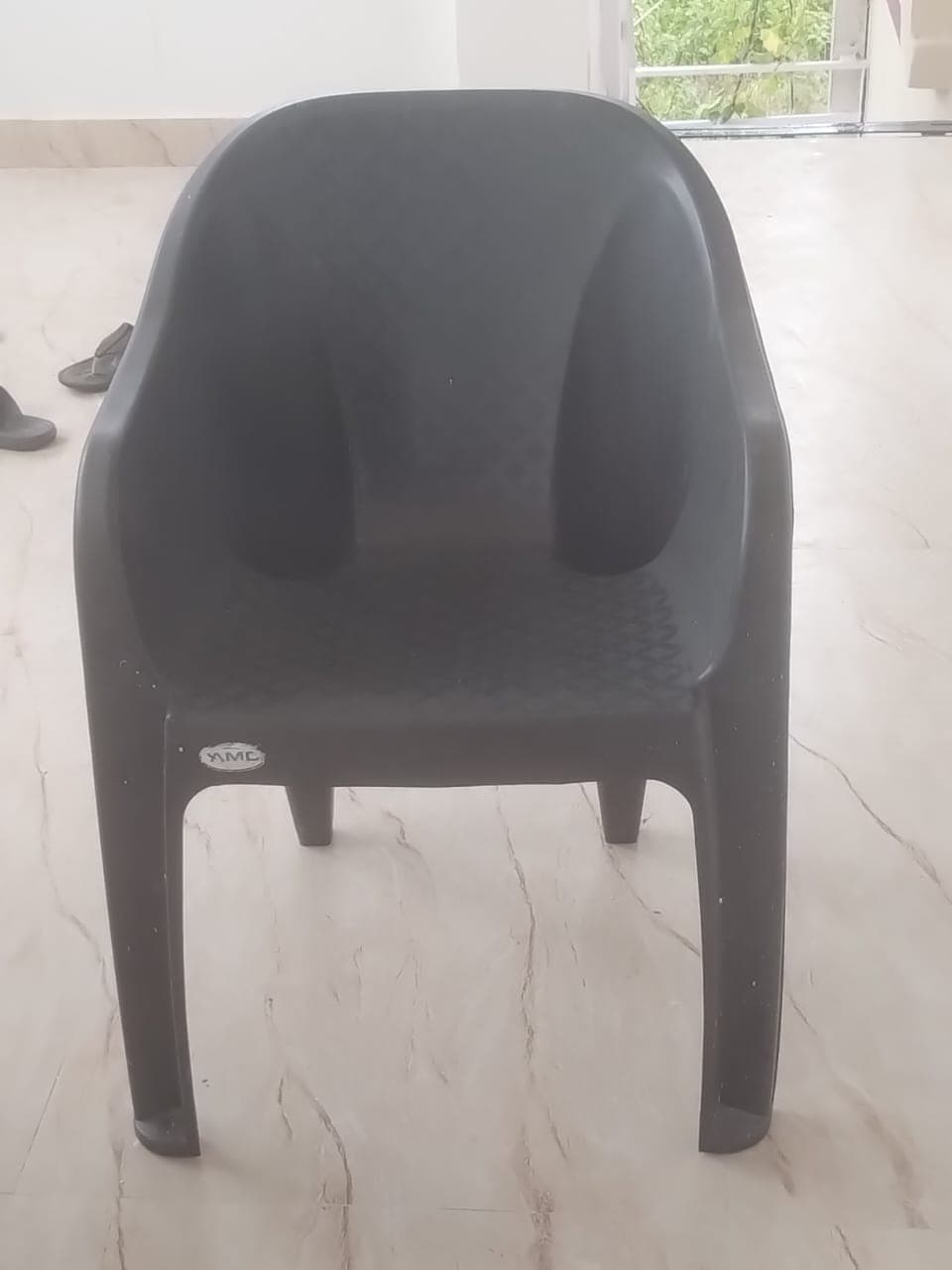 A dark grey, single-piece molded plastic armchair featuring integrated armrests and a slightly reclined backrest. The seat and back exhibit a textured, crosshatch pattern for enhanced grip and visual interest. It stands on four sturdy, tapered legs that are integral to the chair's overall molded structure. — 3D model