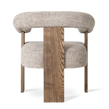 A modern armchair with a curved, upholstered backrest that extends into armrests. The frame consists of prominent, angular wooden legs and supports. The upholstery is a textured, light-colored fabric. — 3D model