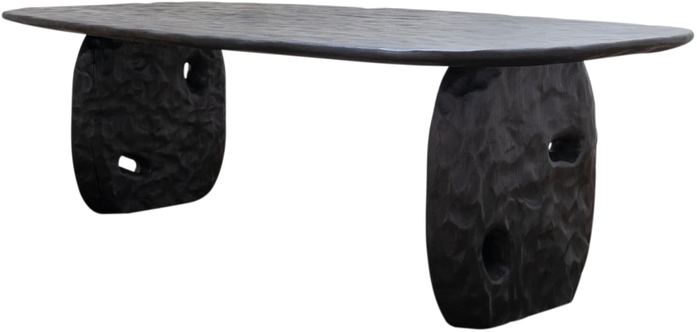 A low-profile coffee table featuring a thick, organically shaped tabletop supported by two robust, sculpted pedestal legs. The entire piece is crafted from dark wood with a heavily textured, hand-carved or hammered finish, and the legs include irregular cutout details. Its design suggests an organic modern or brutalist aesthetic. — 3D model