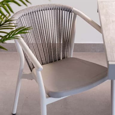 A modern armchair with a white frame and a woven rope backrest. It features a cushioned seat in a light grey fabric. The armrests are integrated into the frame, and the legs are slender and cylindrical. — 3D model