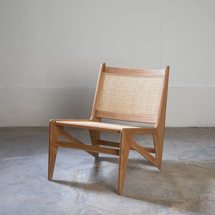 An armless lounge chair featuring a frame constructed from light-toned oak wood, with both the seat and backrest composed of woven natural cane. The chair has a low profile, a slightly reclined back, and gently splayed, tapered legs, exuding a minimalist and modern aesthetic. — 3D model