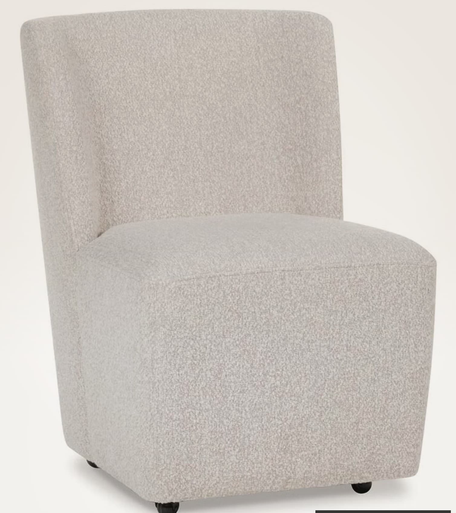 A fully upholstered armless accent chair featuring a light beige, textured boucle fabric. The chair has a minimalist design with a continuous, integrated backrest and seat, soft rounded edges, and no visible legs, presenting a solid, block-like silhouette. — 3D model