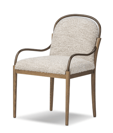 An armchair with a upholstered seat and back, featuring a textured cream-colored fabric. The frame consists of wooden legs and a wooden horizontal support, complemented by curved metal armrests with a bronze finish. The design blends natural and metallic elements. — 3D model