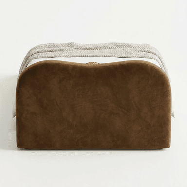 A modern upholstered bed featuring a distinctive wavy headboard and a low-profile frame. The bed is covered in a rich, brown velvet-like fabric, presenting a soft and luxurious appearance. It is dressed with clean white bedding, including two standard pillows and a duvet, accented by a round mustard-colored velvet pillow and a chunky knit beige throw blanket draped across the foot of the bed. The overall design emphasizes organic shapes and contemporary elegance. — 3D model