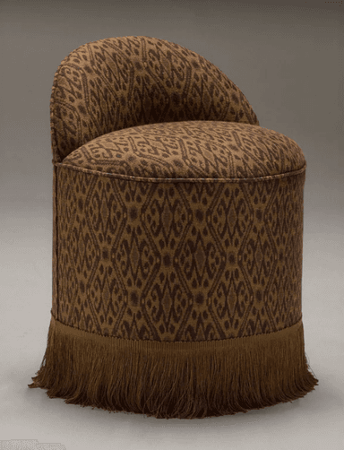 A round stool with a high, curved backrest. The stool is upholstered in a patterned fabric and features a decorative fringe along the bottom edge. — 3D model