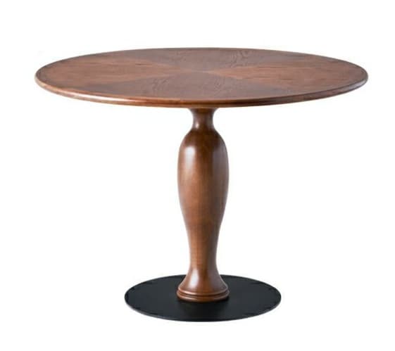 A round wooden table featuring a turned wooden pedestal base and a circular black metal footplate. The tabletop exhibits a distinct wood grain pattern radiating from the center. — 3D model